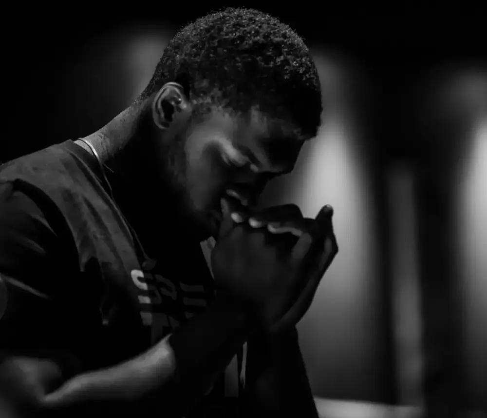man praying in black and white